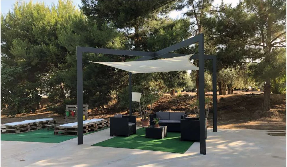 Pérgola de acero gris con una lona blanca en un jardín